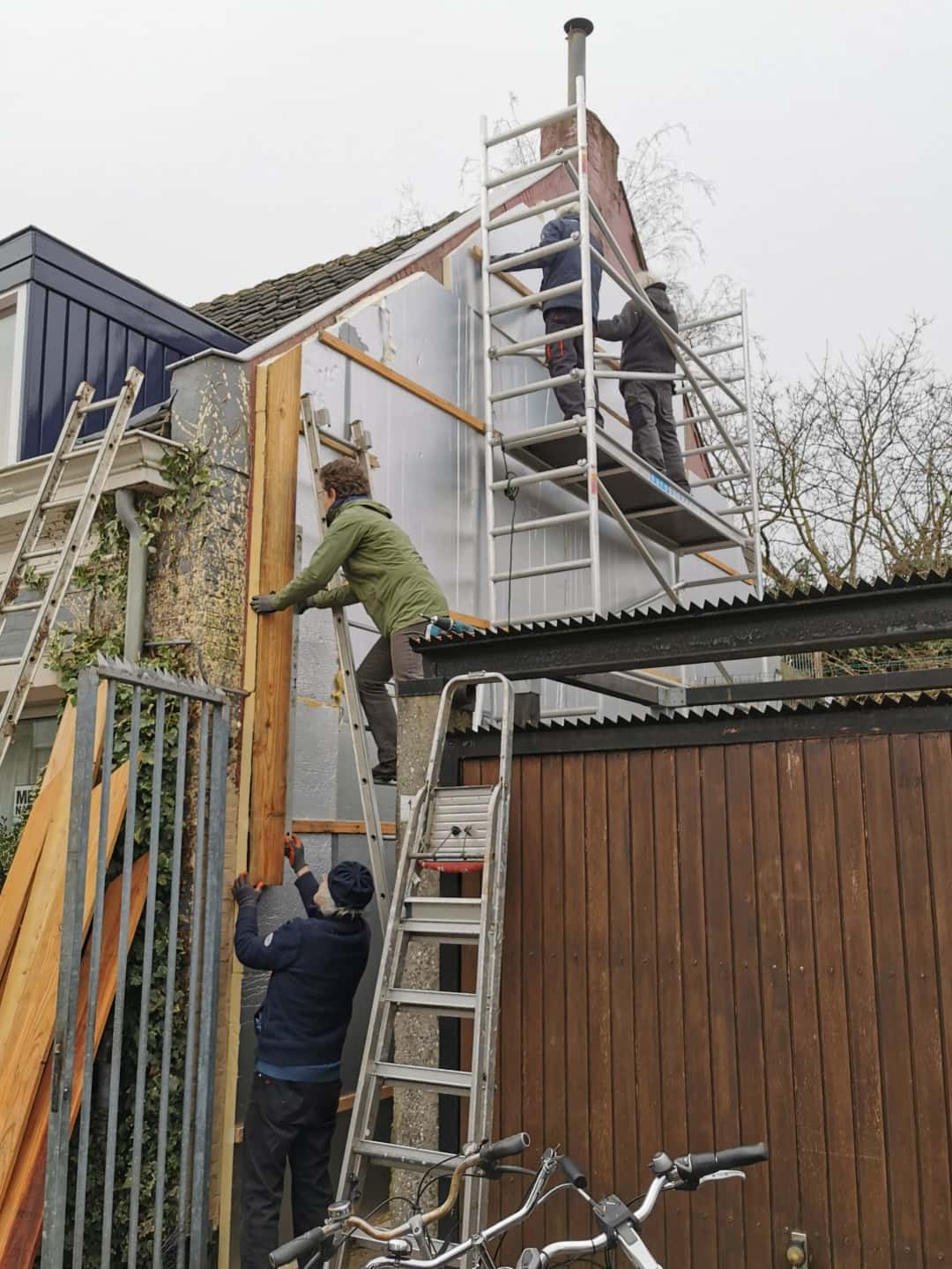 Klimaatklussres druk aan de slag om een wand in te pakken